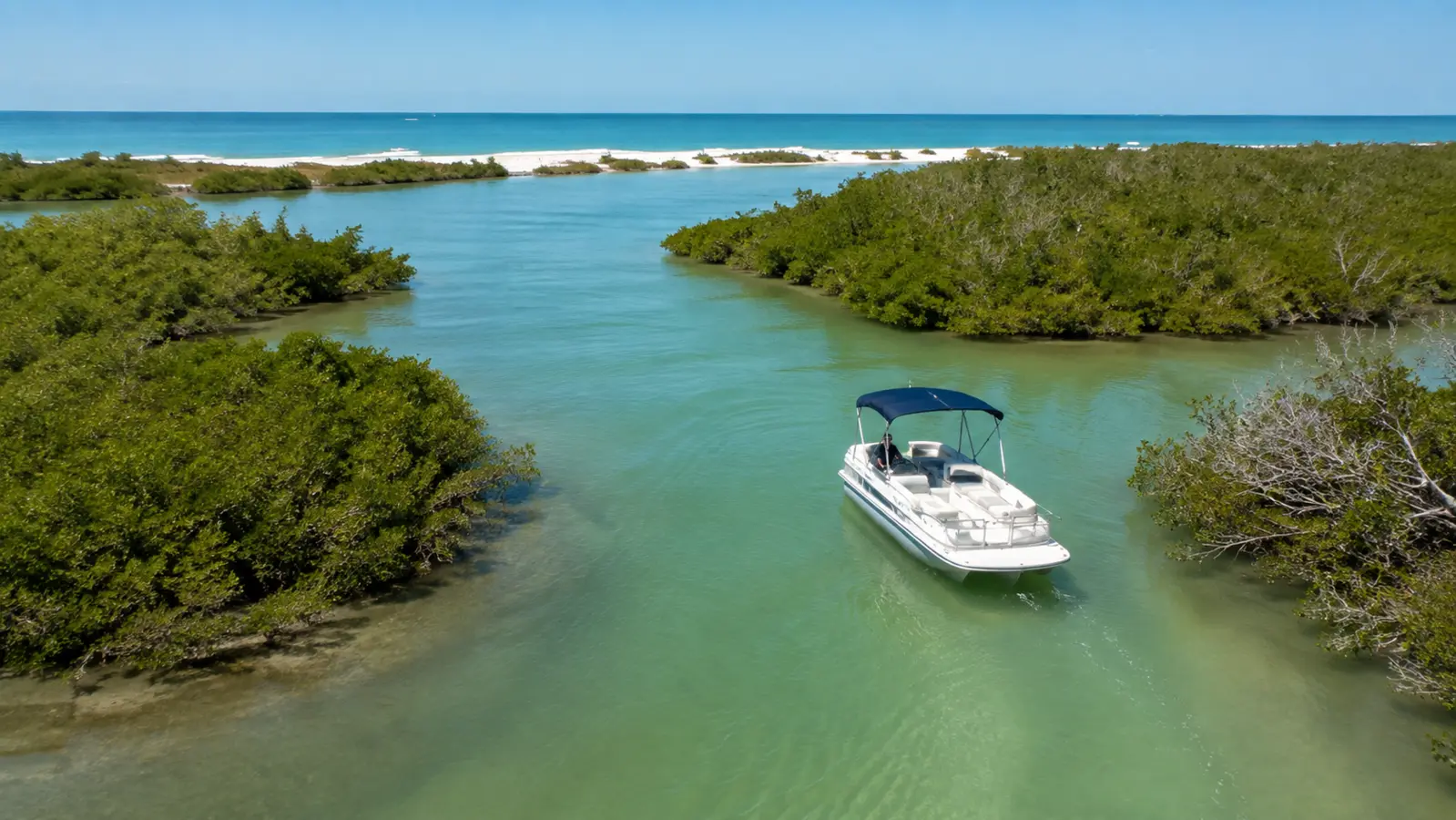 Hurricane-style deck boat traveling through a protected mangrove channel near the Gulf