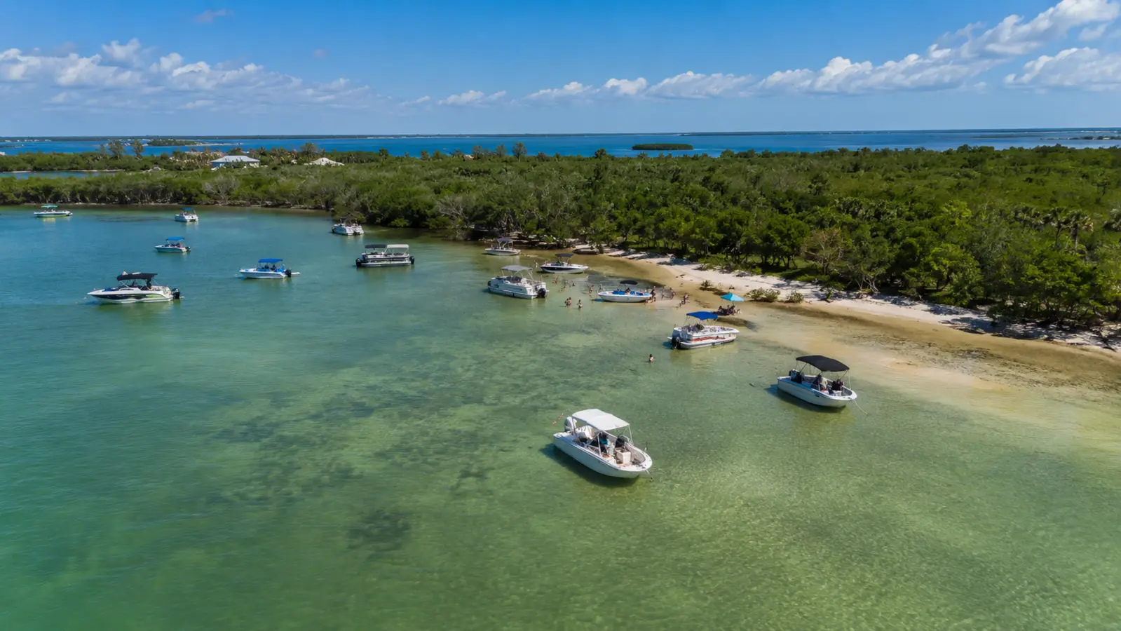 Boats traveling through a protected coastal waterway bordered by mangroves